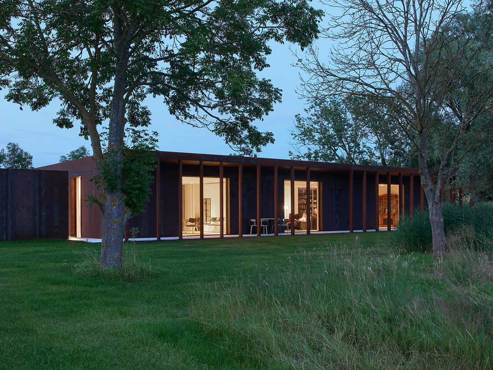 Modern house exterior with evening lighting.