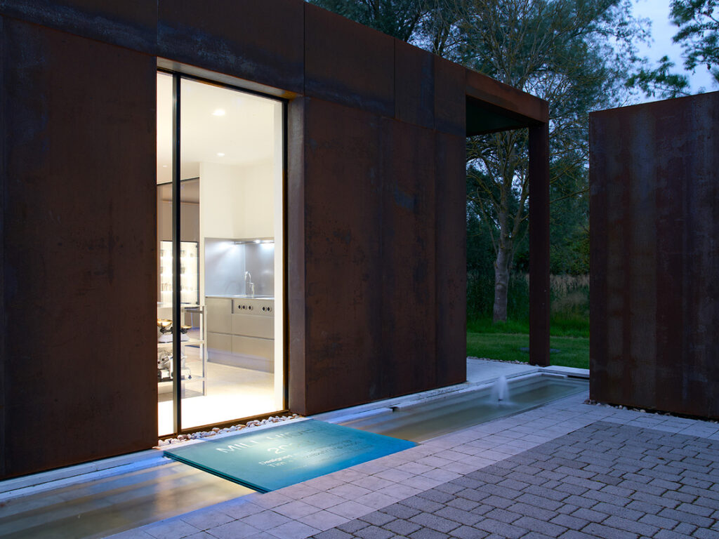 Modern building with open door at dusk.