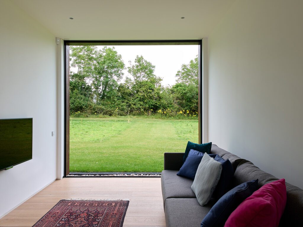 Modern lounge with garden view through large window.